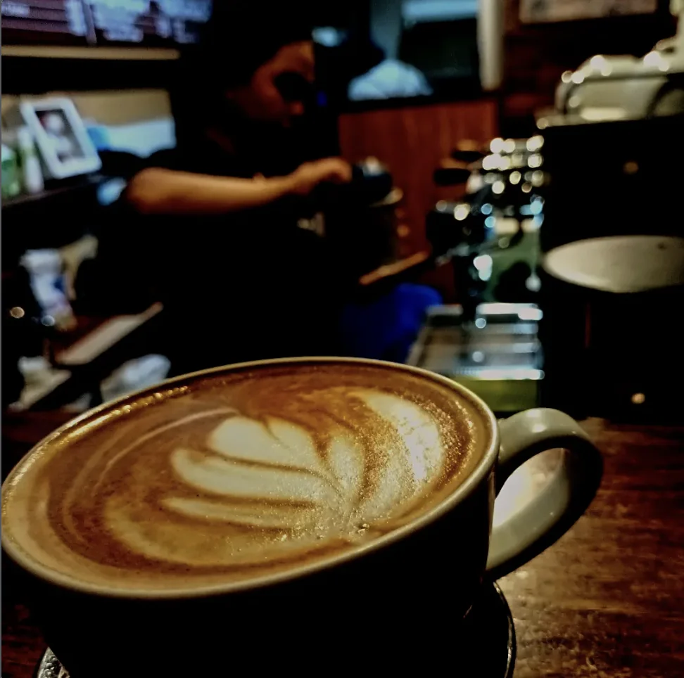 A cup of coffee with latte art at the café counter