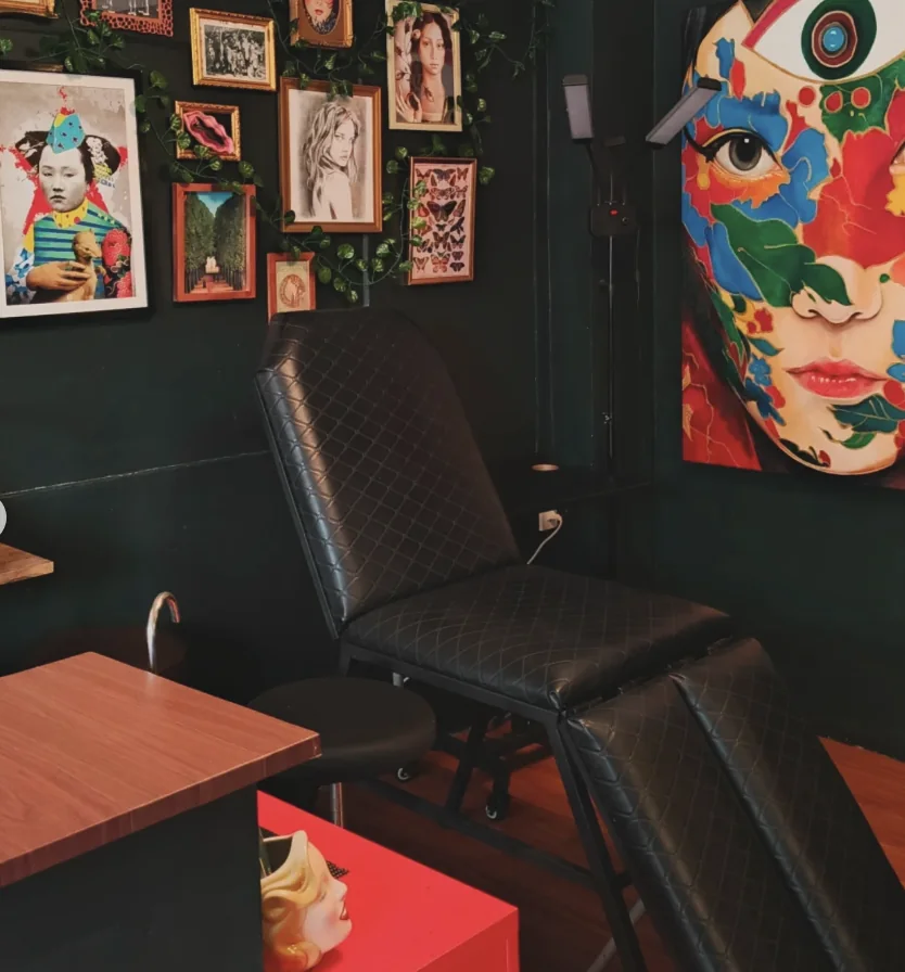 A tattoo chair and framed artwork inside Vidi Vici Tattoo Studio
